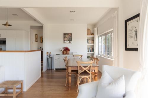 a kitchen and dining room with a table and chairs at The Vintage Cottage in Oneroa