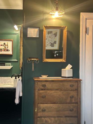 a bathroom with a wooden dresser and a mirror at Oxford House Inn in Fryeburg