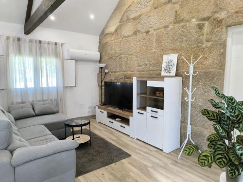 a living room with a couch and a tv at Casa Fontenlos in Tui