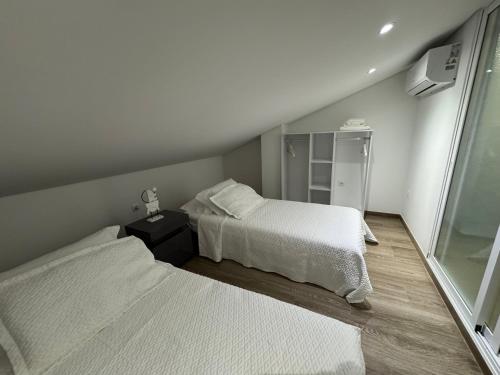 ein Schlafzimmer mit zwei Betten und einem Spiegel in der Unterkunft Malecón Do Azeite in Moura