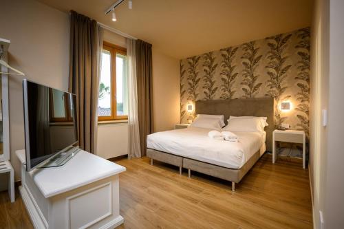 a bedroom with a bed and a desk and a tv at Campiglione Hotel in Bastia Umbra