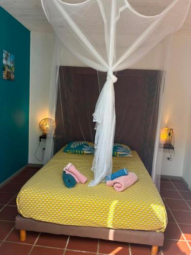 a bedroom with a bed with towels on it at Villa Piscine - Maracudja in Les Anses-dʼArlets