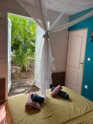 a bedroom with a bed with towels and a window at Villa Piscine - Maracudja in Les Anses-dʼArlets