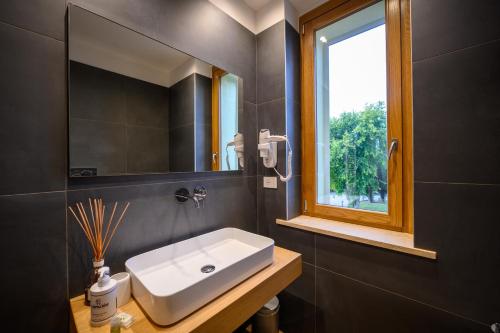 a bathroom with a white sink and a window at Campiglione Hotel in Bastia Umbra