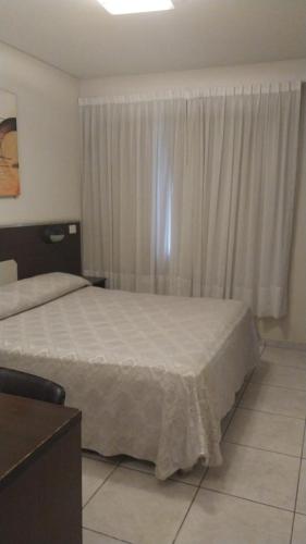 a bedroom with two beds and a window with curtains at Hotel Nontue Abasto Buenos Aires in Buenos Aires