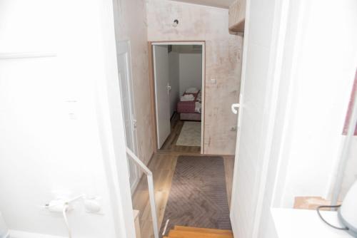 a small bathroom with a hallway leading to a bedroom at Rečni Povetarac in Niš