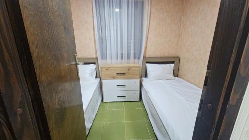 a small room with two beds and a window at ČANJ Apartman Slavica in Čanj