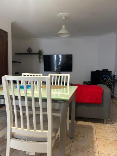 a kitchen with a table and two white chairs at Casa do Evaristo in Nabais