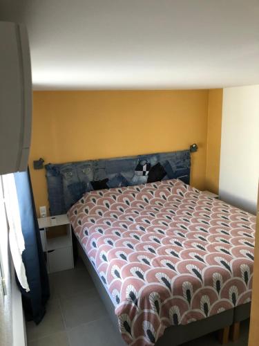 a bedroom with a bed and a yellow wall at Gîte Apaisant in Llauro