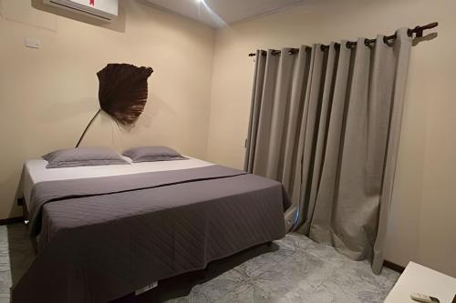 a bedroom with a bed and curtains in it at Chalé Private c/ Vista e garagem in Ilhabela