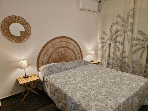a bedroom with a bed and a mirror on the wall at Amandine - Vue mer Pointe-à-Pitre in Pointe-à-Pitre