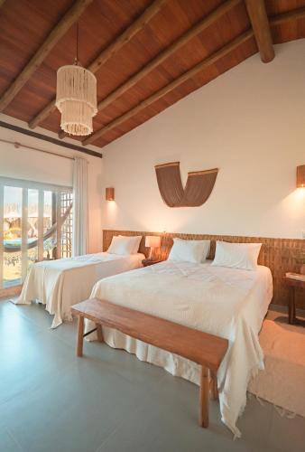 a bedroom with two beds and a chandelier at Falésias Orybá in Corumbau