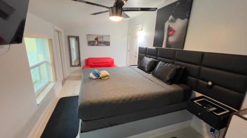 a small bedroom with a bed and a red couch at Billy's Resort- Men Only - Solo Hombres in Wilton Manors