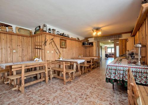 a kitchen with wooden walls and tables and benches at Dom Wypoczynkowy Skorusa in Białka Tatrzanska