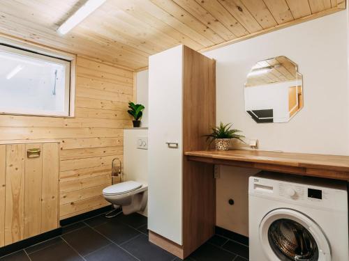a bathroom with a toilet and a washing machine at Barney in Rauris