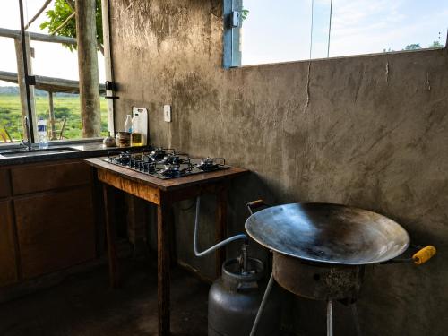 a kitchen with a table and a stove and a counter at Recanto da Cuesta in Botucatu