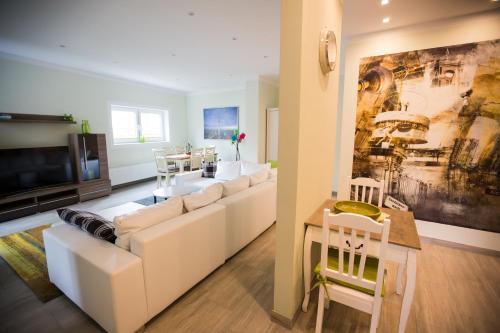 a living room with a white couch and a table at Wassersport-Appartements am Stößensee in Berlin