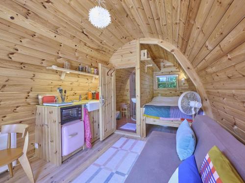 a log cabin with a kitchen and a bedroom at Tiny House Jet in Goedereede