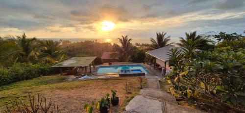 a villa with a swimming pool and the sunset at Casas vacacionales Sofioli in Pedernales