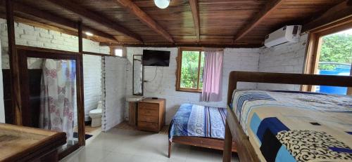 a bedroom with a bed and a television in a room at Casas vacacionales Sofioli in Pedernales