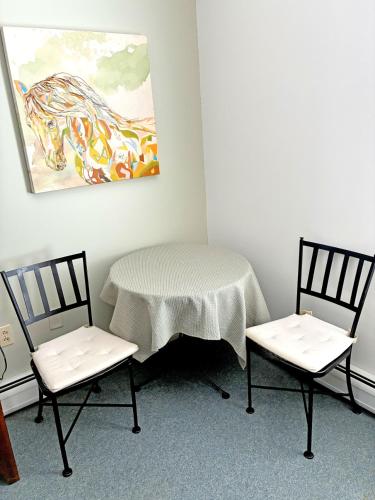 a table and two chairs in a room with a painting at Bristol Suites in Bristol