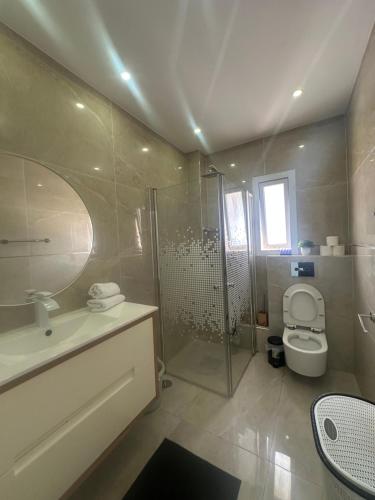 a bathroom with a shower and a toilet and a sink at Beachfront Haven - Perfect for Groups in Ashdod