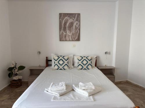 a bedroom with a large white bed with two pillows at Creta Sun Apartments in Makrigialos Sea-view in Makry Gialos