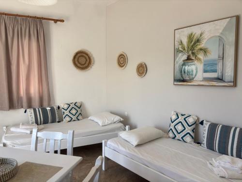 a living room with two couches and a table at Creta Sun Apartments in Makrigialos Sea-view in Makry Gialos