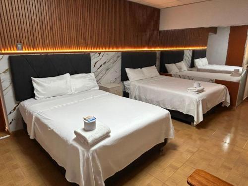 a hotel room with two beds and a couch at Hostal La Huerta in Huánuco