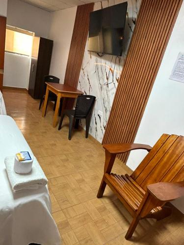 a hotel room with a wooden chair and a table at Hostal La Huerta in Huánuco