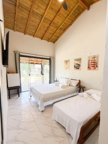 two beds in a room with a window at Hospedagem Ratzke in Paraty