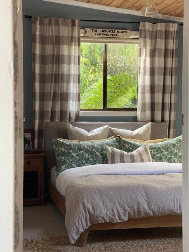 a bedroom with a bed with green and white pillows at Travellers Rest Bicheno in Bicheno