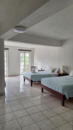 a bedroom with two beds and a tile floor at Los Pueblitos de Guanajuato in Guanajuato