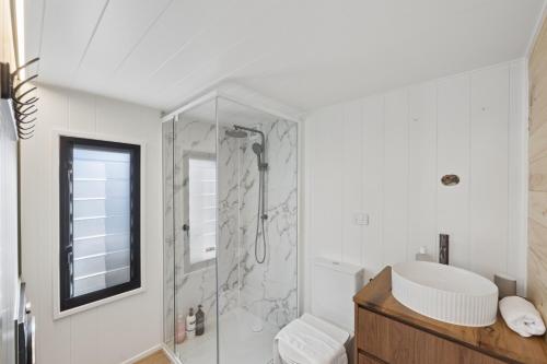 a bathroom with a shower and a toilet and a sink at Ginger GOAT - Luxury New Tiny Home in Jindabyne
