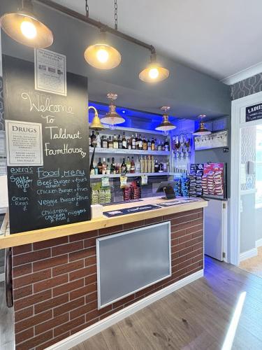 a bar with a chalkboard on the wall at Taldrwst At Dwyran in Dwyran