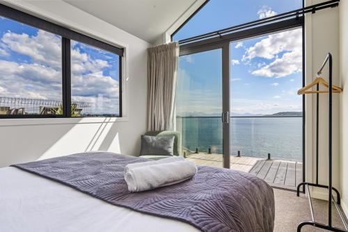 a bedroom with a bed and a large window at Roam Taupo Upper Terrace Unit 3 - Spa Pool in Taupo