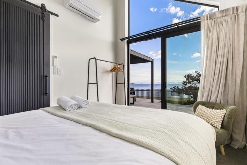 a bedroom with a large bed and a large window at Roam Taupo Lake Front Unit 2 - Spa Pool in Taupo
