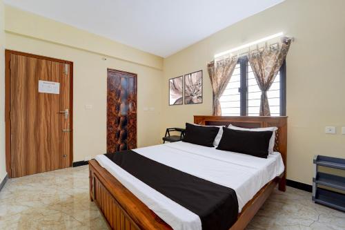 a bedroom with a large bed and a window at Super Collection O Madurai Junction Formerly RLR Enclave in Madurai