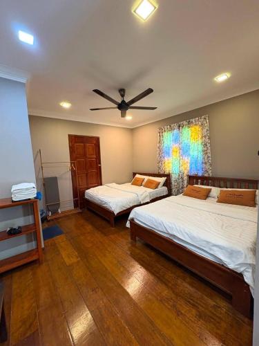 a bedroom with two beds and a ceiling fan at Rivora Gopeng in Gopeng