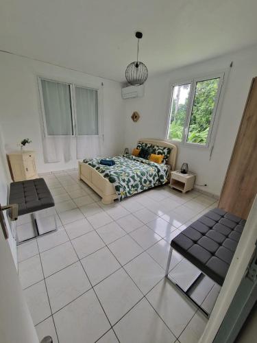 a bedroom with a bed and a tiled floor at La Casa Bongo - T4 cosy en pleine nature in Capesterre-Belle-Eau