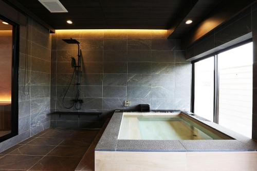 a bathroom with a large tub with a shower at Manten no Tsujinoya in Komatsu