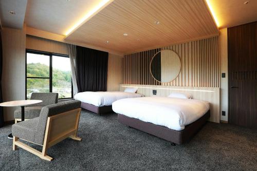 a hotel room with two beds and a table at Manten no Tsujinoya in Komatsu