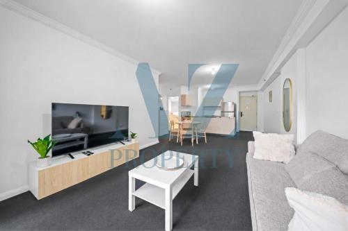 a living room with a couch and a tv at Perth CBD Hideaway Walk to Everything in Perth
