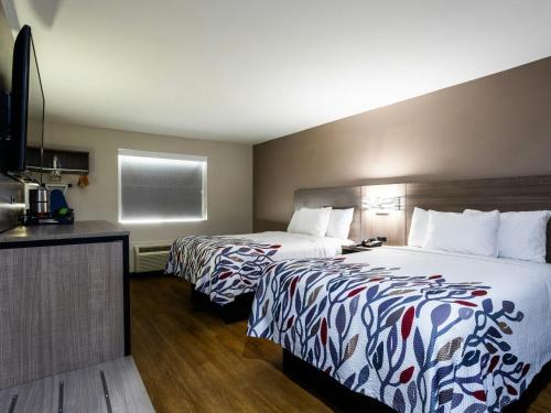 a hotel room with two beds and a kitchen at Red Roof Inn Binghamton North in Binghamton