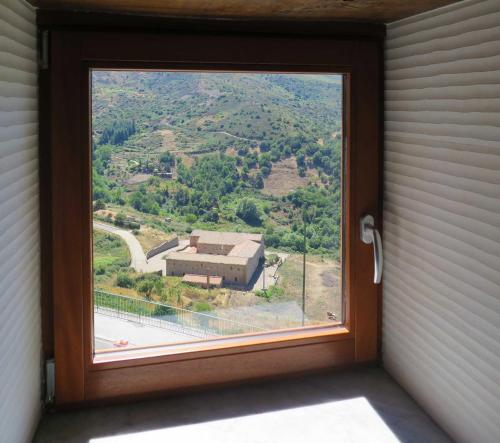 a window with a view of a house at Porta Baciamano in Geraci Siculo
