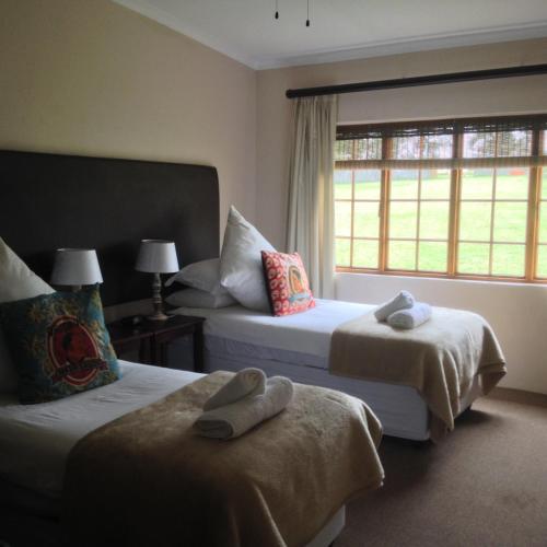 a hotel room with two beds and a window at Lanseria Country Estate in Lanseria