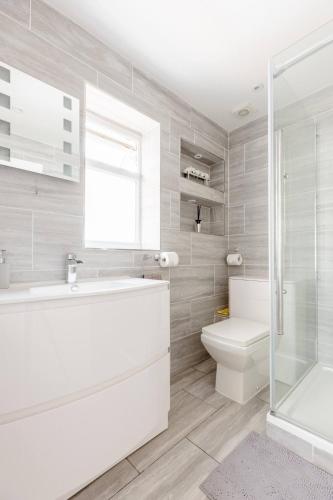 a white bathroom with a tub and a toilet at Single Room with shared bathroom in Cheshunt