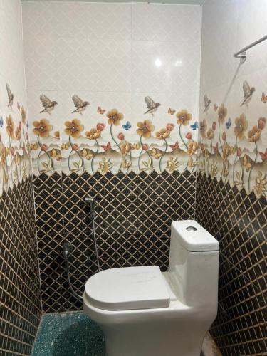 a bathroom with a toilet and a tiled wall at Vijay residency TVR in ThiruvÄrÅ«r