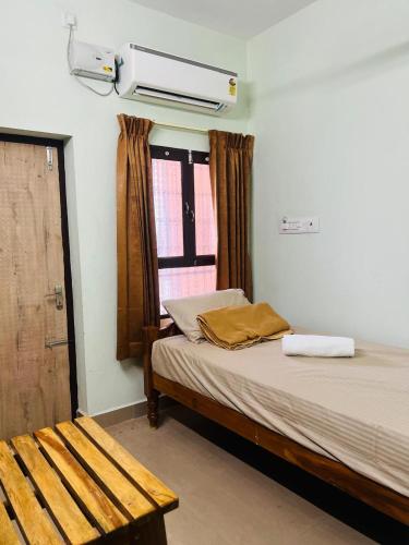 a bedroom with a bed and a window at Vijay residency TVR in ThiruvÄrÅ«r