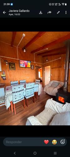 a room with a table and chairs and a television at Cabaña entre mares Huelmo in Puerto Montt